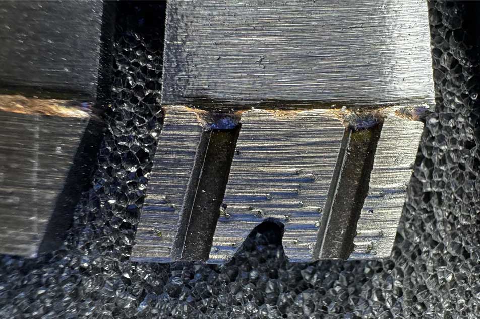 Close-up of a saw blade tooth with a textured surface