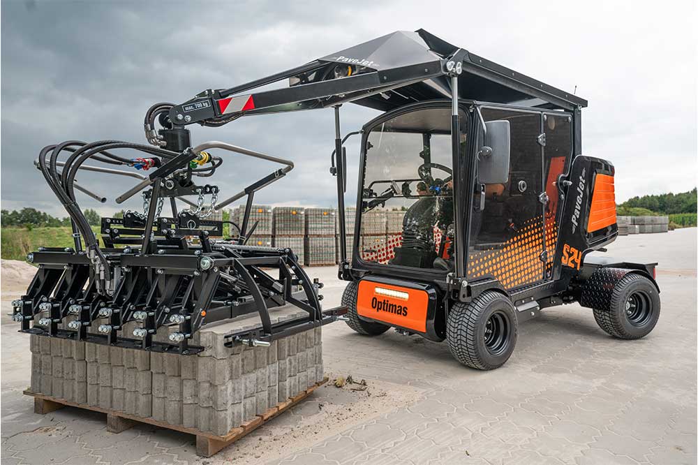 An orange and black S24 PaveJet paver laying machine with a black cabin, mounted on a construction vehicle.