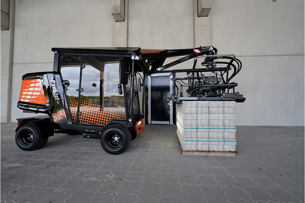 An orange and black S24 PaveJet paver laying machine laying pavers
